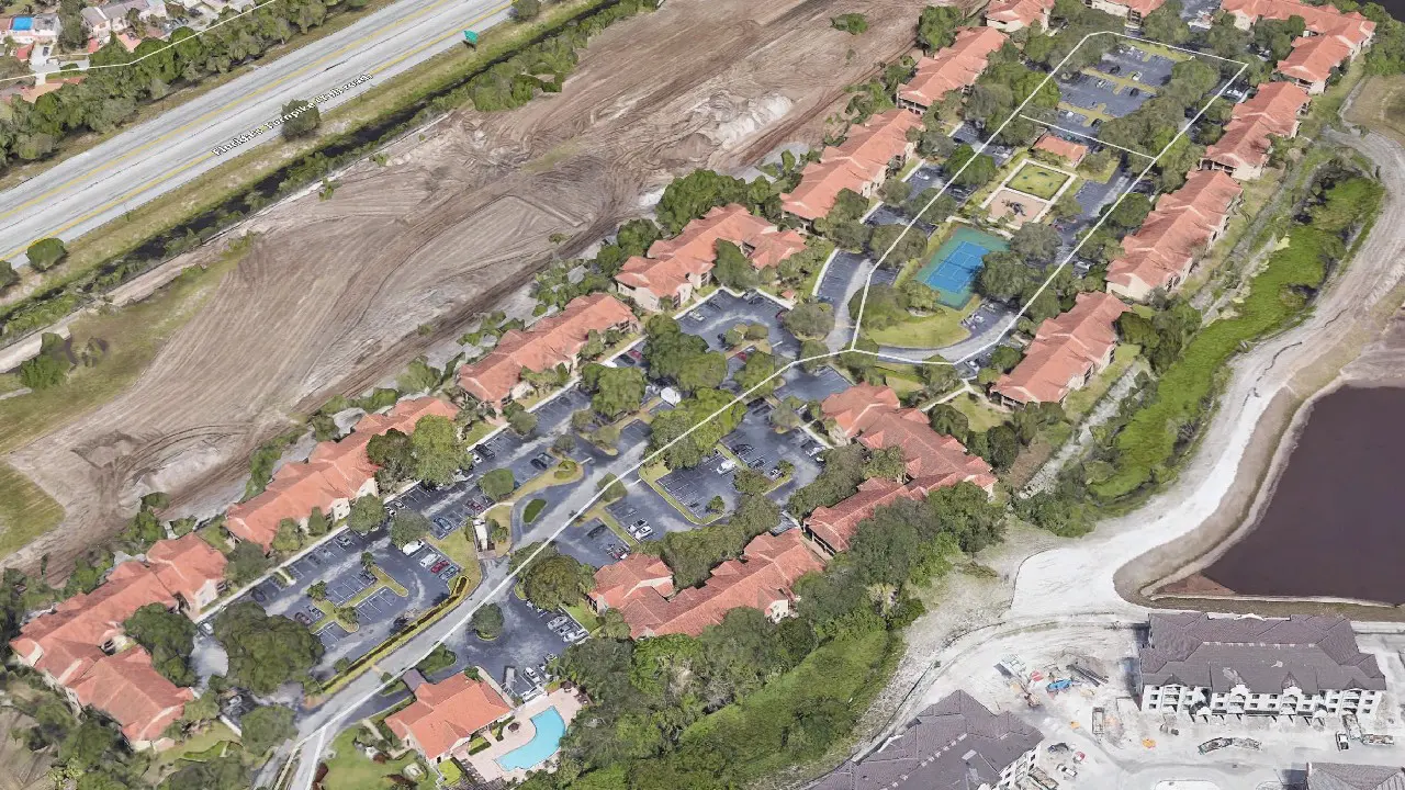 Aerial view of a residential complex beside cleared construction land