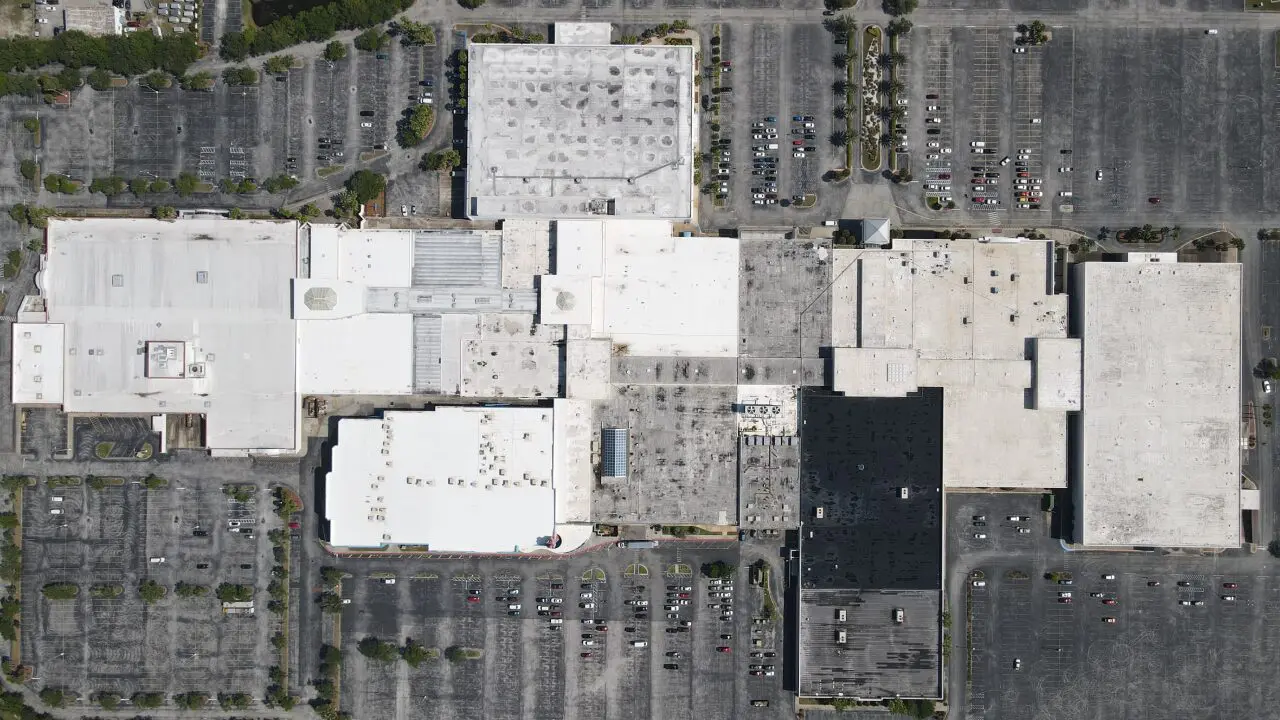 Overhead aerial view of a shopping mall roof and parking lots