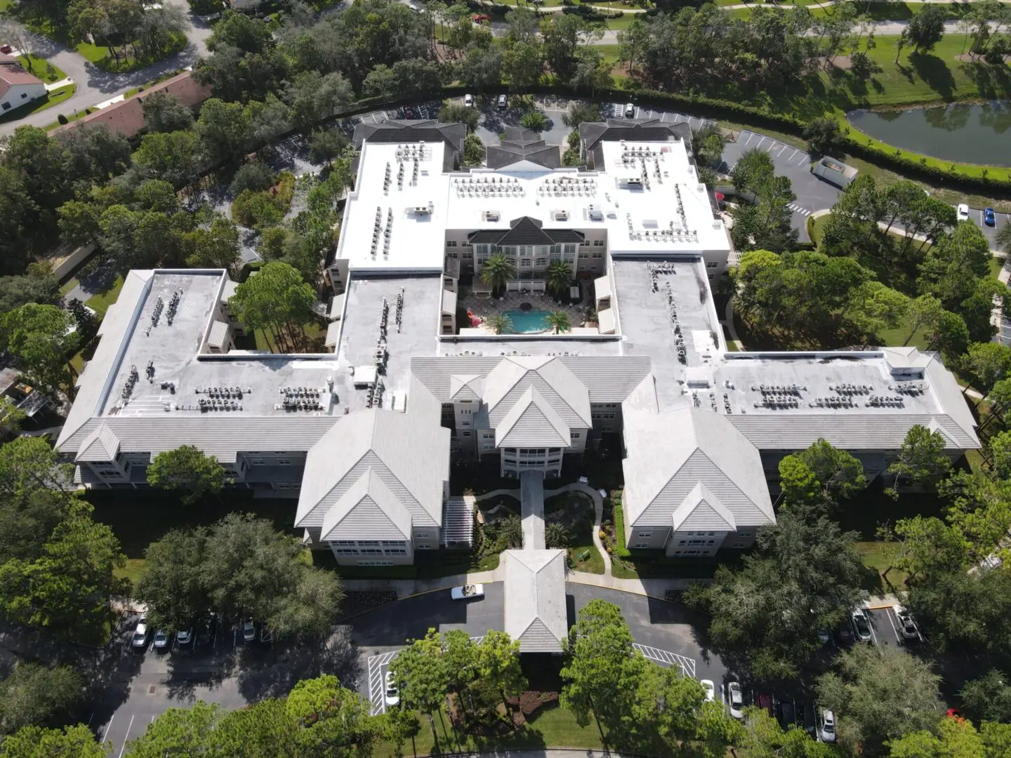 Aerial view of a multi-building residential complex with a central courtyard pool